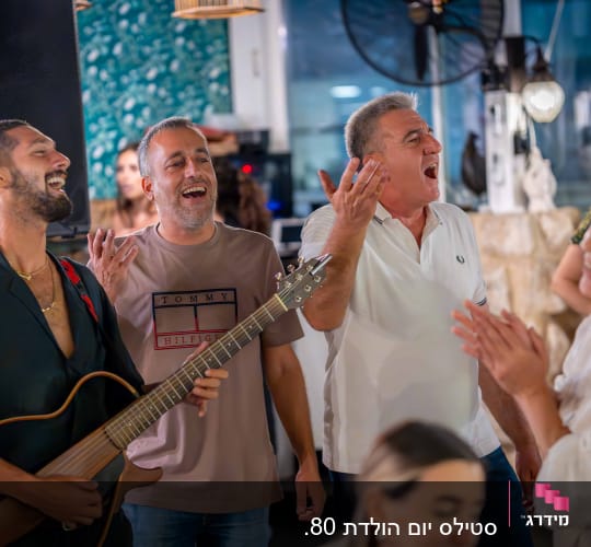 אנשים שרים ומנגנים בגיטרה באירוע חברתי